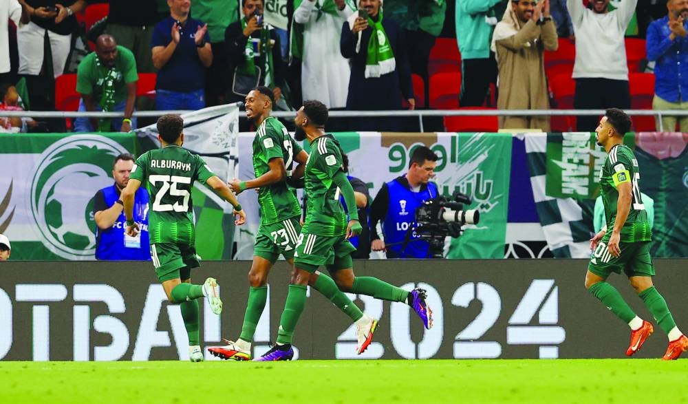 Saudi Arabia’s Mohamed Kanno celebrates scoring their first goal with teammates against Kyrgyzstan during their AFC Asian Cup Group F clash at Ahmad Bin Ali Stadium, Al Rayyan, yesterday. (Reuters)