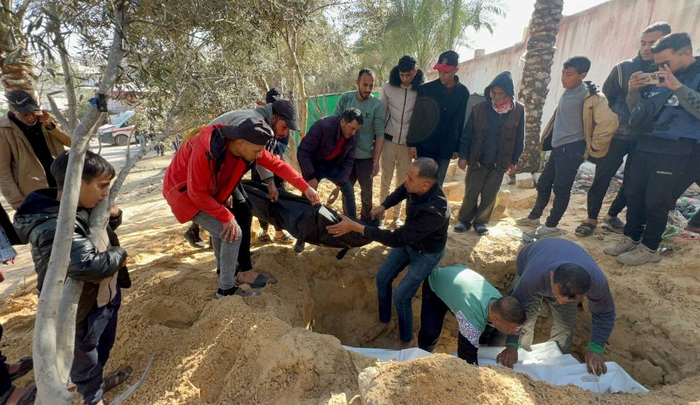 People bury bodies of Palestinians killed in an Israeli strike, at the Nasser hospital premises as Palestinians cannot reach the cemetery due to the Israeli ground operation, in Khan Younis in the southern Gaza Strip, on Monday. REUTERS