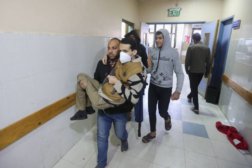 A Palestinian man wounded in an Israeli strike is rushed into Nasser Hospital in Khan Younis in the southern Gaza Strip, on Monday. REUTERS