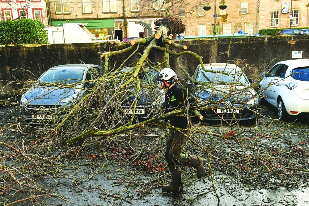 
A tree surgeon removes a fallen tree from cars during Storm Isha in Linlithgow. 