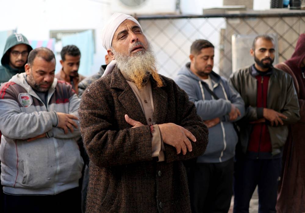 People pray next to dead bodies, including those of Palestinians killed in Israeli strikes in Khan Younis, after they were brought into al-Najjar hospital, in Rafah in the southern Gaza Strip, on Wednesday. REUTERS