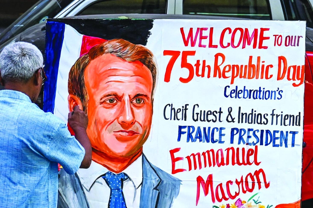 An artist gives finishing touches to a painting of French President Emmanuel Macron outside an art school in Mumbai.