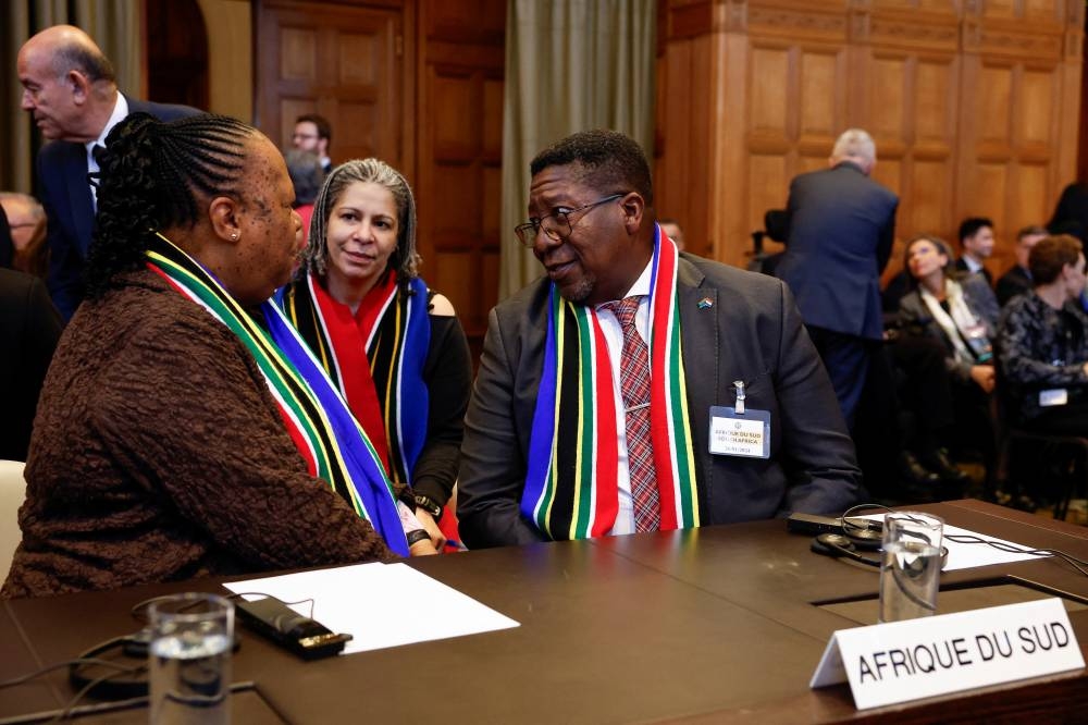 South Africa's President Ramaphosa's legal advisor, Nokukhanya Jele, listens as South African Foreign Minister Naledi Pandor and South African Ambassador to the Netherlands Vusimuzi Madonsela speak on the day the International Court of Justice (ICJ) rule on emergency measures against Israel following accusations by South Africa that the Israeli military operation in Gaza is a state-led genocide, in The Hague, Netherlands, on Friday. REUTERS