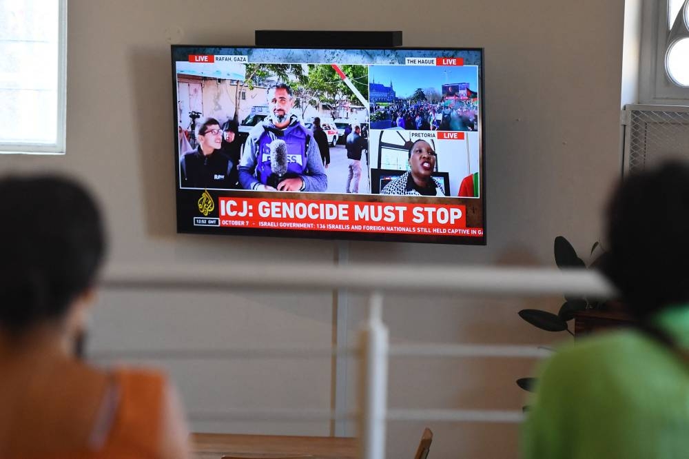 People gather to watch the International Court of Justice (ICJ) ruling of the case against Israel brought by South Africa in The Hague at the Bertha House in Cape Town on  Friday. AFP