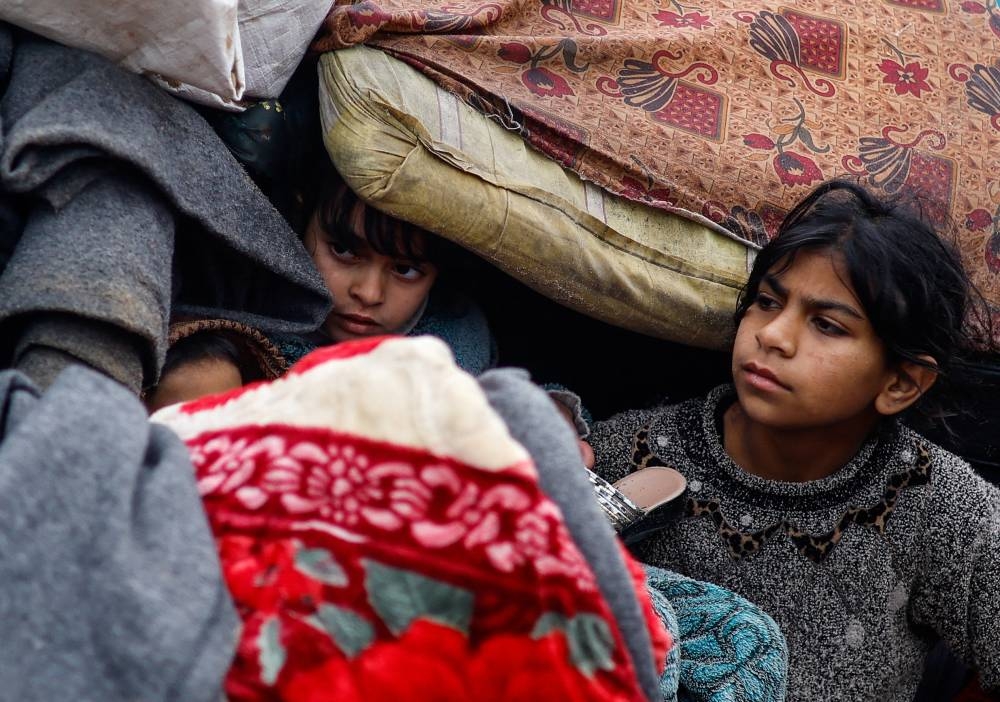 Children look on as Palestinians fleeing Khan Younis, due to the Israeli ground operation, move towards Rafah in the southern Gaza Strip, on Saturday. REUTERS