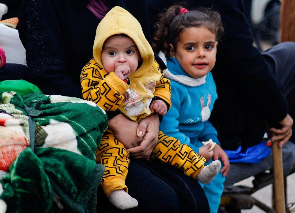 Children rest as Palestinians fleeing Khan Younis, due to the Israeli ground operation, move towards Rafah in the southern Gaza Strip, on Saturday. REUTERS
