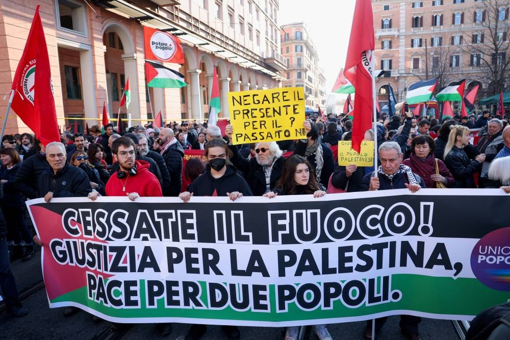 Pro-Palestinian protestors hold a banner during a demonstration demanding an immediate ceasefire in Gaza, in Rome, Saturday. The banner reads: "Cease fire! Justice for Palestine, peace for two peoples." REUTERS