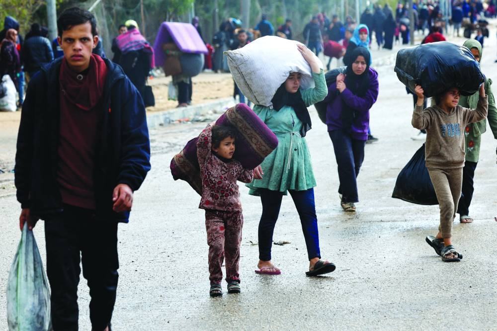 Children carry belongings as Palestinians flee Khan Younis, in the southern Gaza Strip, Monday.