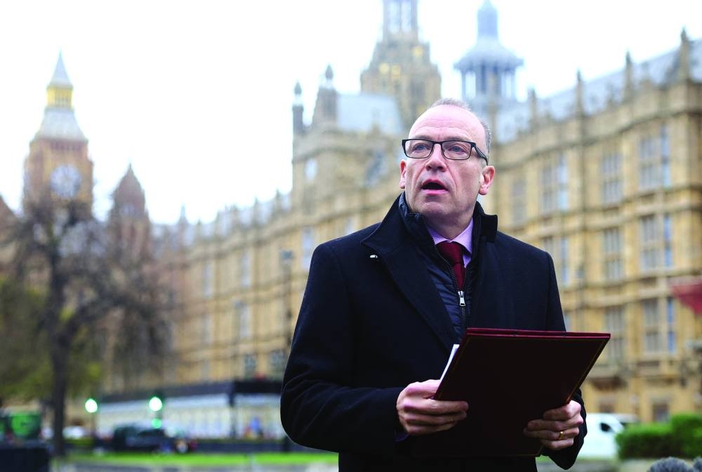 
British Secretary of State for Northern Ireland Chris Heaton-Harris delivers a statement to media members near the Houses of Parliament in London. 
