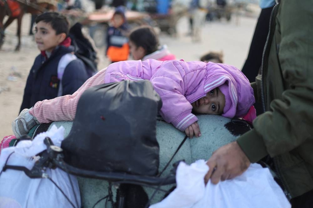 A child lies on a bicycle packed with belongings, as Palestinians flee Khan Younis towards Rafah in the southern Gaza Strip, on Tuesday. REUTERS
