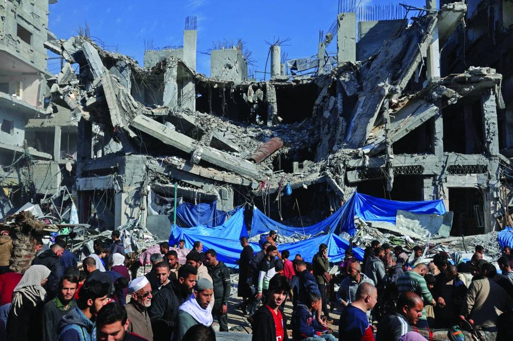 Palestinians shop in an open-air market near the ruins of houses and buildings, in Nuseirat refugee camp in the central Gaza Strip.