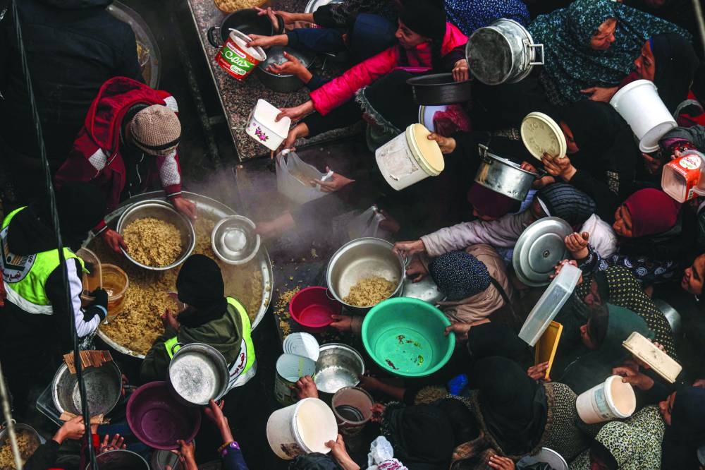 Palestinians receive food rations at a donation point at a camp for internally displaced people in Rafah in the southern Gaza Strip, yesterday.