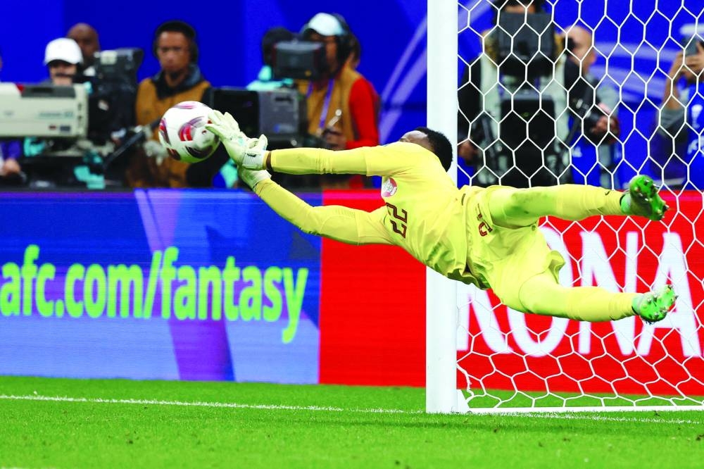 
Qatar’s goalkeeper Meshaal Barsham saves a shot by Uzbekistan’s midfielder Jaloliddin Masharipov during the penalty shootout at Al Bayt Stadium. (AFP) 