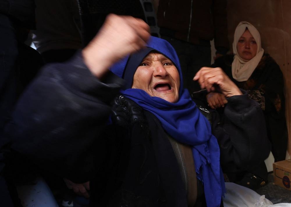 Mourners react next to the bodies of two Palestinian children killed in Israeli strikes in Rafah on Sunday. REUTERS