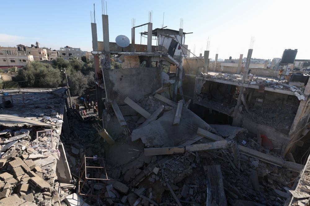 Palestinians gather at the site of an Israeli strike on a residential building in Rafah on Sunday. REUTERS