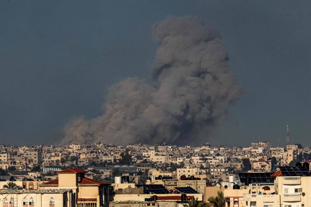A picture taken from Rafah in the southern Gaza Strip shows smoke rising over buildings in Khan Yunis following Israeli bombardment on on Sunday. AFP