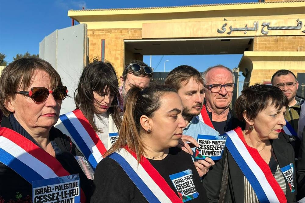 French members of parliament hold placards calling for a ceasefire between Israel and the Palestinian militant group Hamas, during a visit to the Egyptian side of the Rafah border crossing with the Gaza Strip, in the North-eastern Sinai province on Sunday. AFP