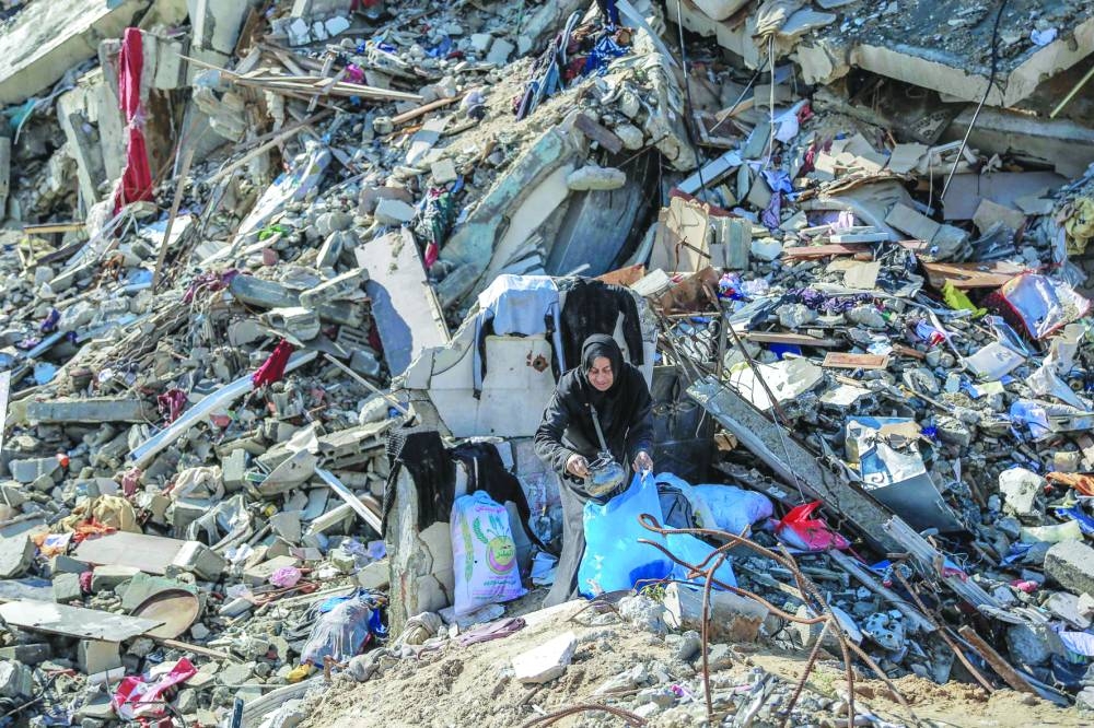 A woman searches for salvageable items on Al-Mukhabarat street in Gaza City.