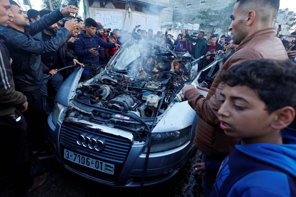 Palestinians react at the site of an Israeli strike on a car in Rafah, in the southern Gaza Strip, on Wednesday. REUTERS