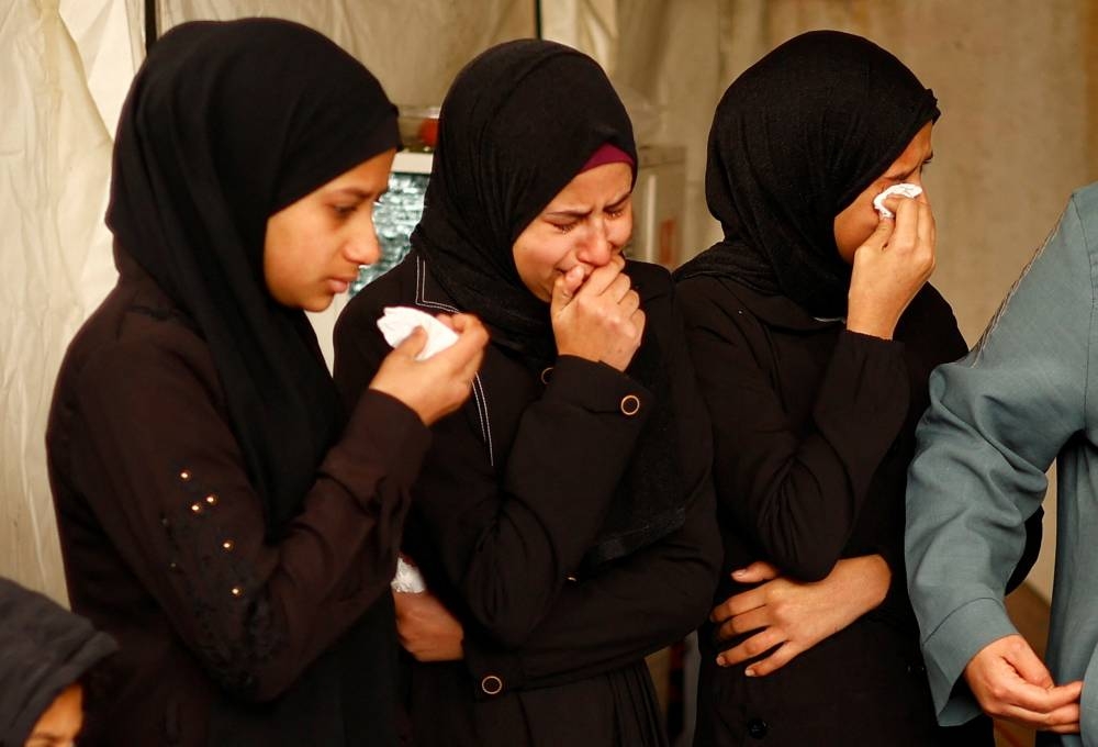 Mourners react next to the bodies of Palestinians two of whom died of natural causes and the rest were killed in Israeli strikes at Abu Yousef al-Najjar hospital in Rafah in the southern Gaza Strip, on Wednesday. REUTERS