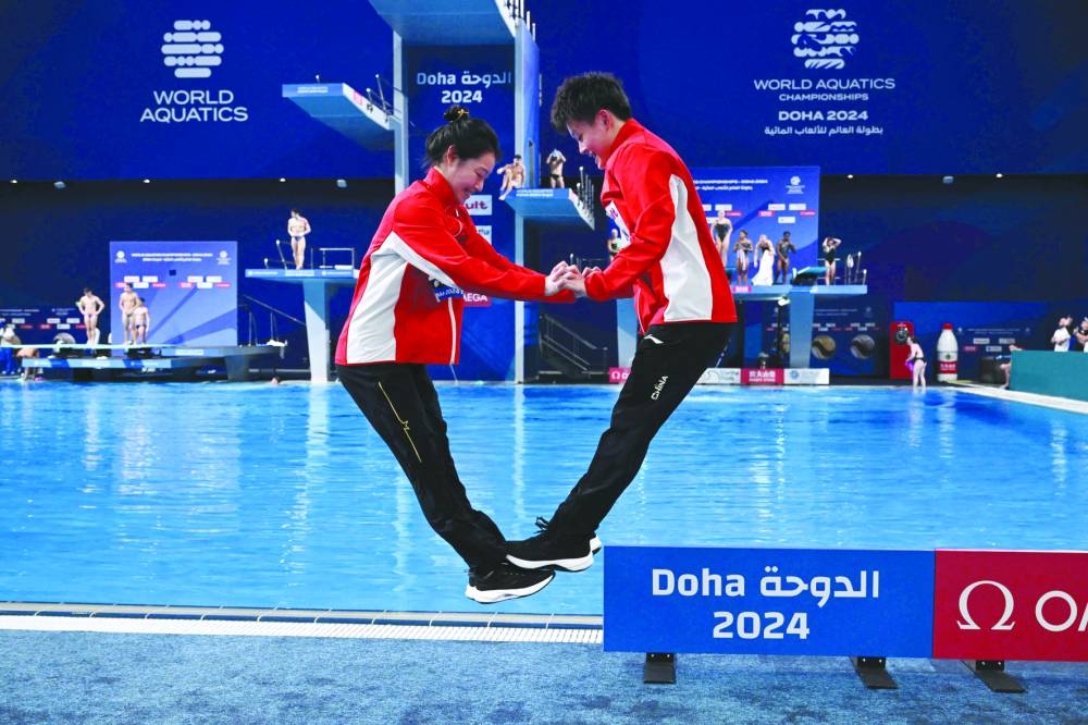
China’s Chang Yani and Chen Yiwen celebrate after winning the gold in the women’s 3m springboard synchro diving event at the Hamad Aquatics Centre. (AFP) 