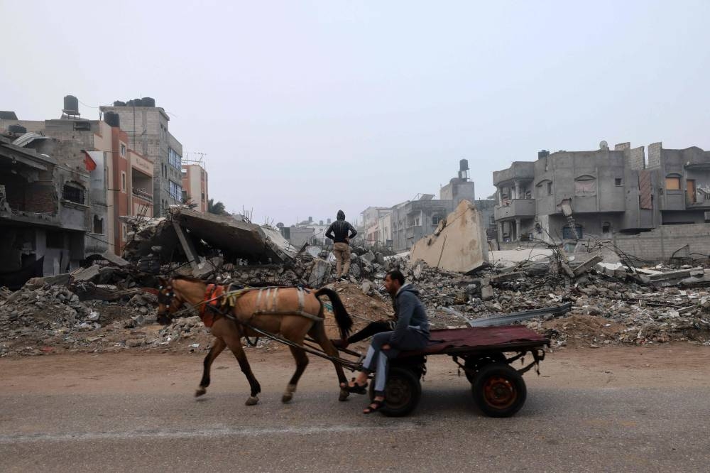 A man rides a horse-pulled cart along a street ravaged by Israeli bombing in Rafah on Friday. AFP