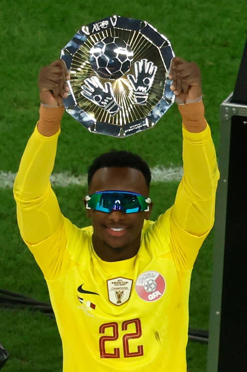 Qatar's goalkeeper #22 Meshaal Barsham celebrates with the Best Goalkeeper Award trophy during the podium ceremony after the AFC Qatar 2023 Asian Cup final football match between Jordan and Qatar at the Lusail Stadium.