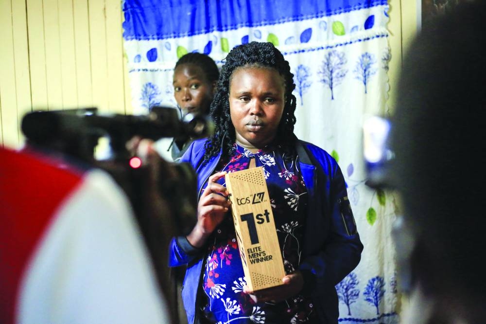 
Aseneth Rotich, wife of Kelvin Kiptum, holds one of his trophies at their home in Chepsamo, Kenya. (AFP) 