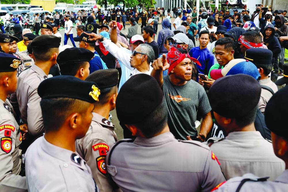 Police officers block pro-government protesters as they approach anti-government protesters holding a rally demanding a fair election, outside the Indonesian parliament in Jakarta, Indonesia, on Monday.