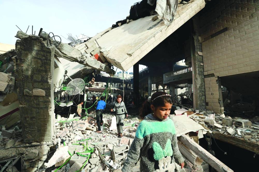 People inspect the damage in the rubble of a mosque following Israeli bombardment, in Rafah, on the southern Gaza Strip, yesterday.
