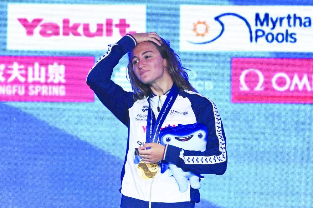 
Gold medallist Italy’s Simona Quadarella poses on the podium of the 1500m freestyle swimming event during the 2024 World Aquatics Championships at Aspire Dome in Doha yesterday. (AFP) 