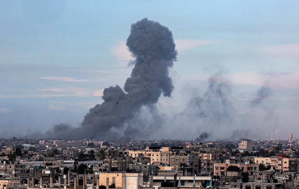This picture taken from Rafah shows smoke billowing over Khan Yunis in the distance following Israeli bombardment on the southern Gaza Strip, on Wednesday. AFP
