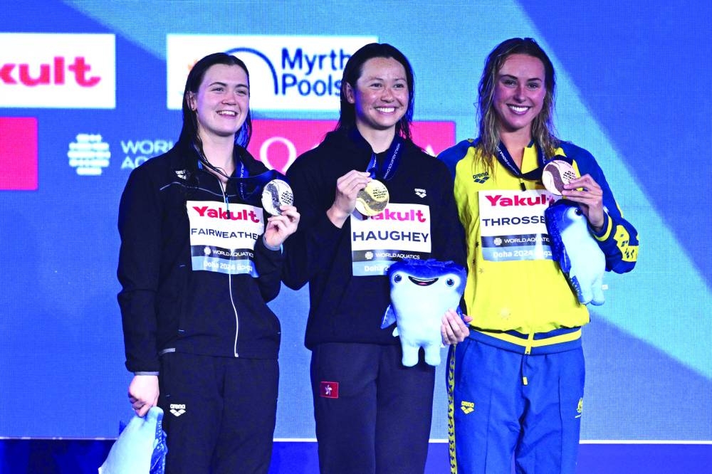(Left to Right) New Zealand’s silver-medallist Erika Fairweather, Hong Kong’s gold-medallist Siobhan Bernadette Haughey and Australia’s bronze-medallist Brianna Throssell pose with their medals on the podium of the women’s 200m freestyle swimming event on Wednesday. (AFP)