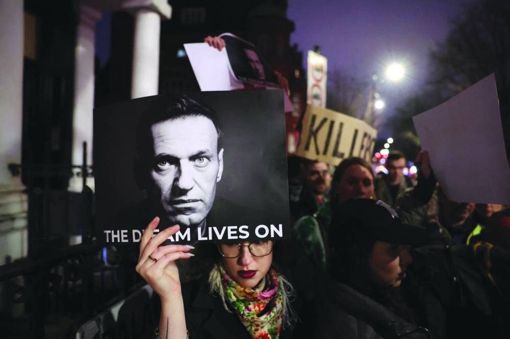 
People gather with placards and photographs outside the Russian embassy in London. 