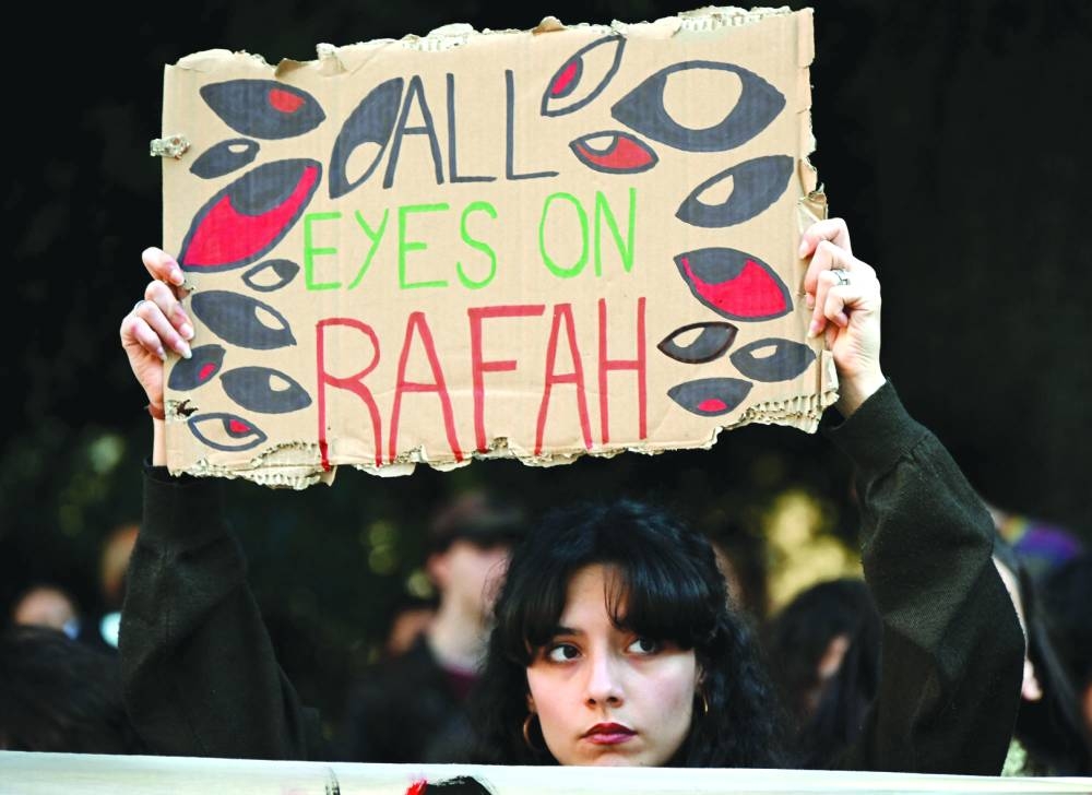 A pro-Palestine demonstrator holds up a placard during in front of the Italian national television headquarter RAI, in central Rome Saturday.