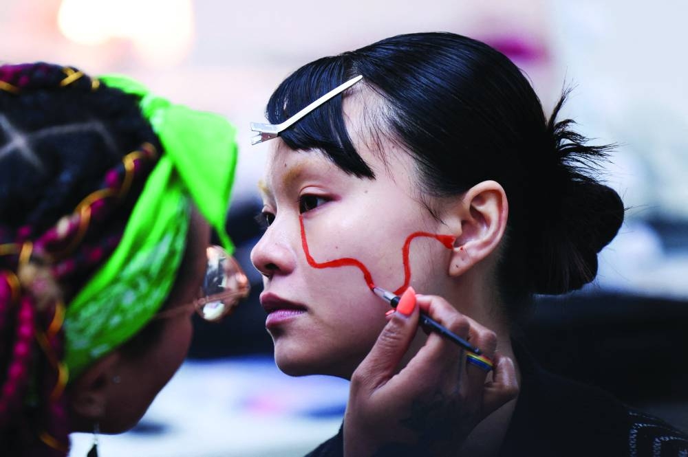 
A model has her face painted backstage for Ones to Watch catwalk show during the London Fashion Week. 