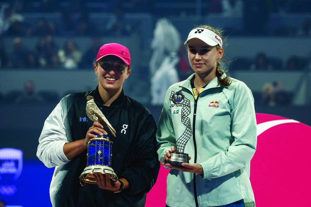 Qatar TotalEnergies Open winner Iga Swiatek (left) of Poland and runner-up Elena Rybakina of Kazakhstan pose with their trophies during a podium ceremony in Doha on Saturday. (AFP)
