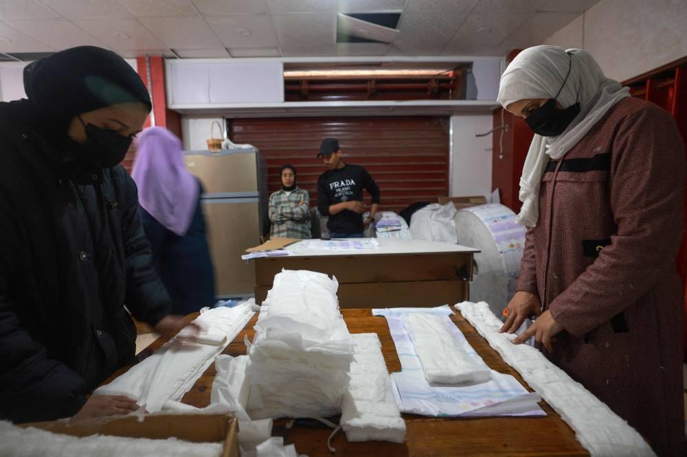 Palestinians sew diapers at a workshop in Rafah in the southern Gaza Strip on Sunday. AFP