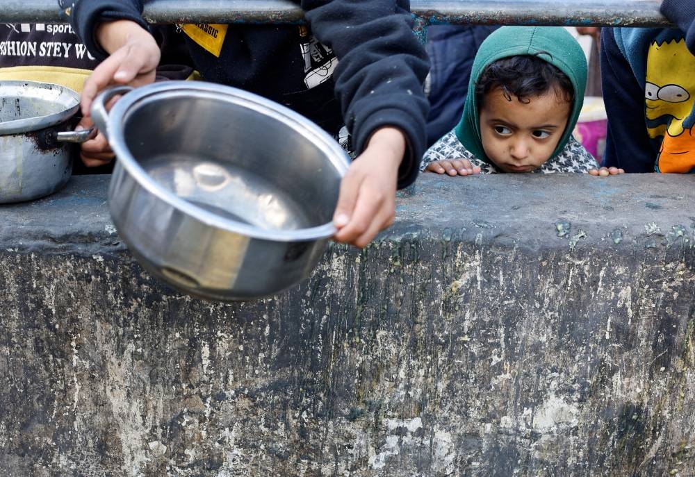 A Palestinian child looks on while waiting to receive food cooked by a charity kitchen amid shortages of food supplies in Rafah, in the southern Gaza Strip, on Tuesday. REUTERS