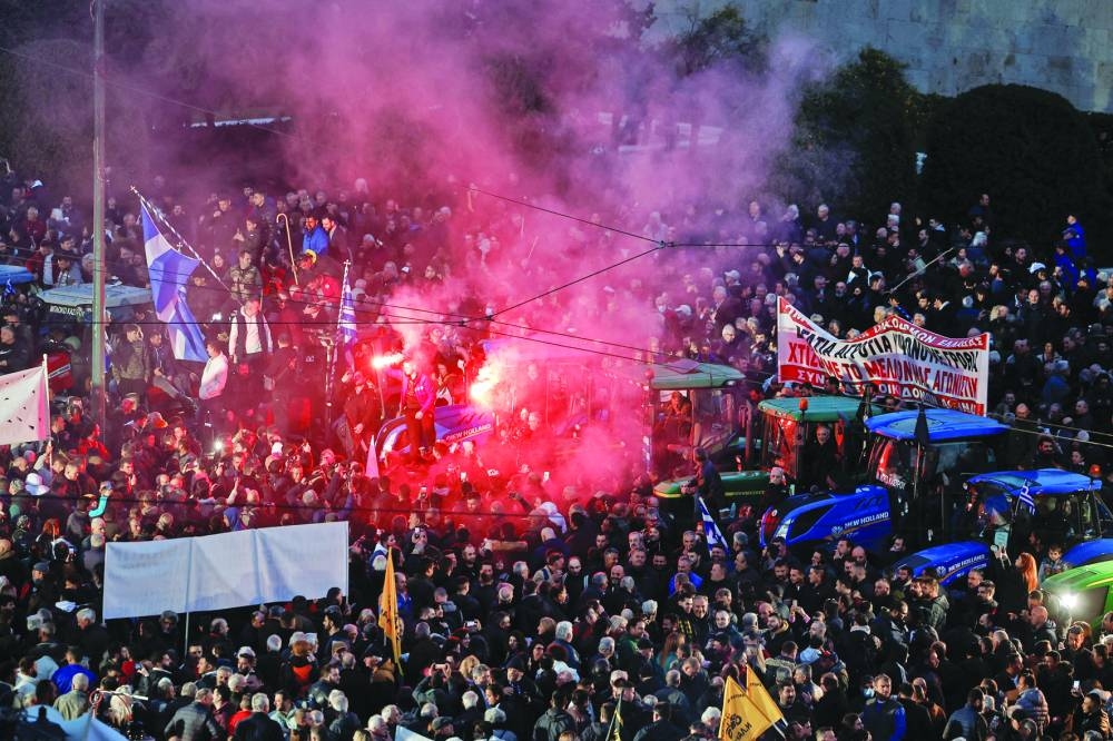 Greek farmers, some lighting flares, gather outside the parliament building with their tractors, during a protest in Athens, while on the border between Poland and Ukraine, Polish farmers block roads in Elblag, Poland.