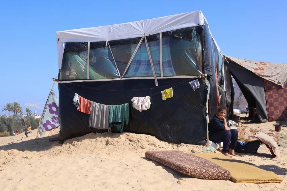 A displaced Palestinian girl sits outside her family's tent, at a tent camp where she shelters in Rafah on Wednesday. REUTERS