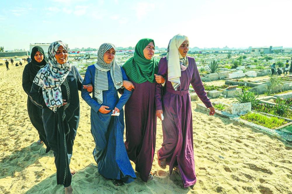 
Palestinians mourn during the funeral of loved ones killed during overnight Israeli strikes, at a cemetery in Rafah, on the southern Gaza Strip, yesterday. 