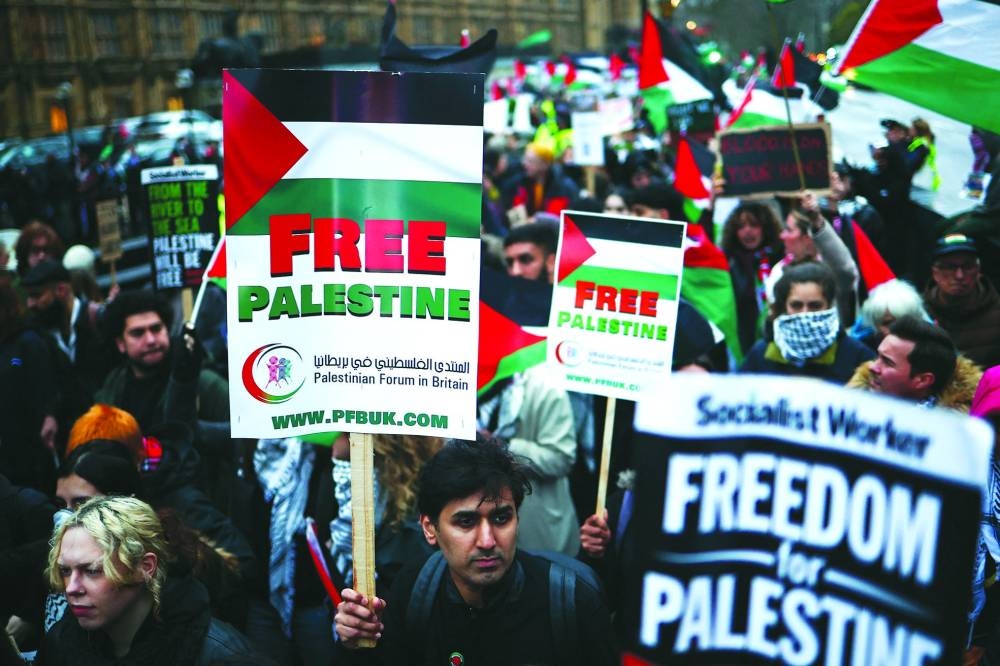 
Demonstrators wave Palestinian flags as they protest in Parliament Square in London, yesterday, during an Opposition Day motion in the House of Commons calling for an immediate ceasefire in Gaza. 