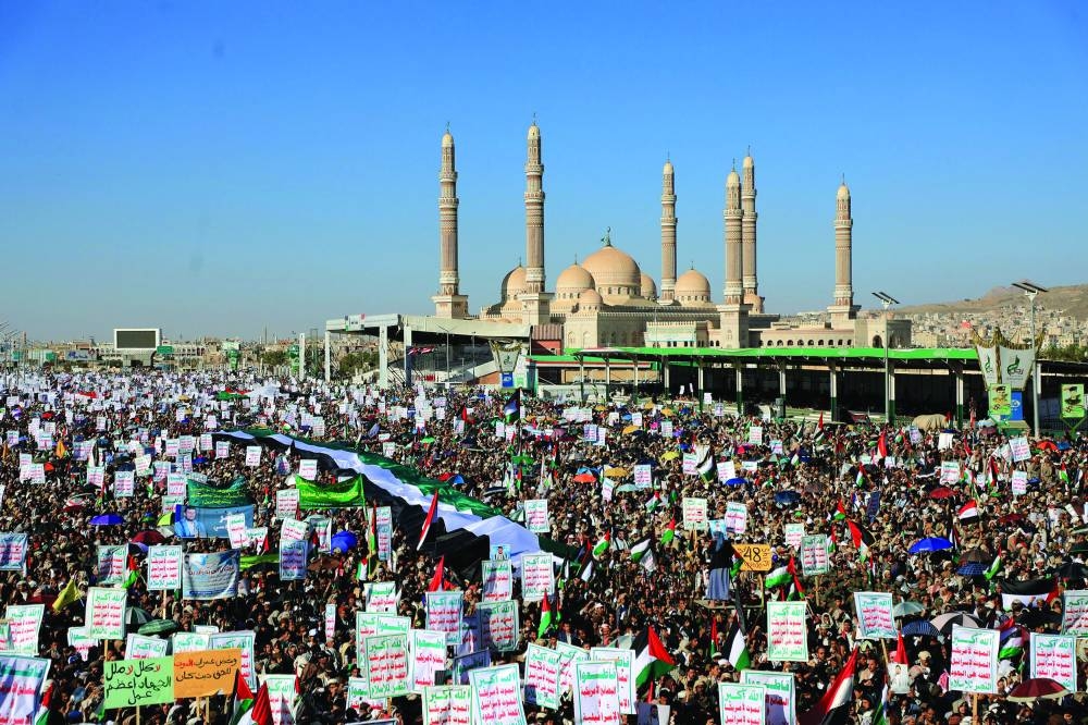 Yemenis lift placards and wave Palestinian flags as they march in the Houthi-run capital Sanaa, yesterday, in support of Palestinians amid ongoing conflict.