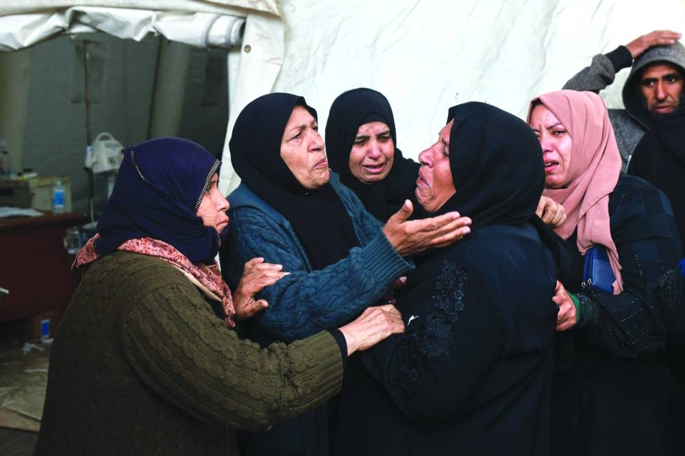 People mourn relatives killed in overnight Israeli bombardment, outside the Al-Najjar hospital in Rafah in the southern Gaza Strip, yesterday.