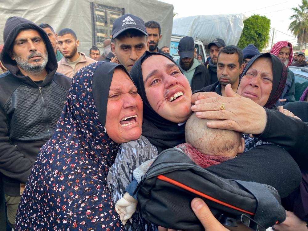 Palestinian woman Noor Al-Dalou carries the body of her son Yasser, who was killed in an Israeli strike at Al-Aqsa hospital in Deir Al-Balah in the central Gaza Strip, Saturday. REUTERS
