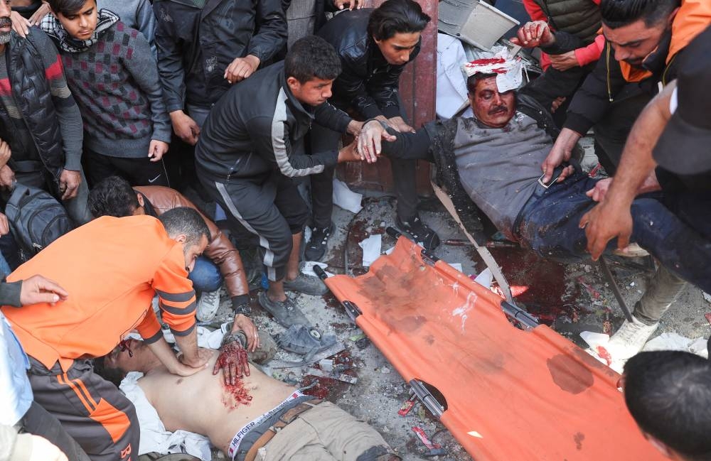 Palestinians attend to casualties, at the site of an Israeli strike on a house in Rafah, in the southern Gaza Strip Saturday. REUTERS