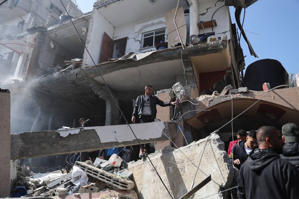 Palestinians inspect the site of an Israeli strike on a house in Rafah, in the southern Gaza Strip Saturday. REUTERS