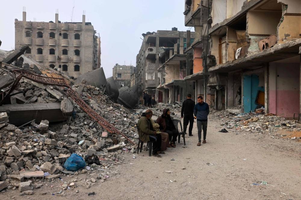 People sit in front of the Al-Faruk mosque, levelled by Israeli bombardment in Rafah in the southern Gaza Strip, Sunday. AFP