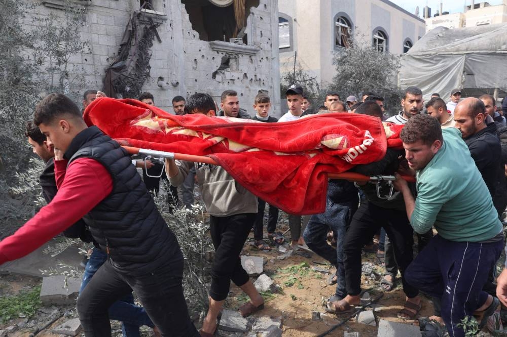 Palestinians carry the body of a person killed in an Israeli bombardment, after being recovered from under the rubble of a home in Rafah in the southern Gaza Strip on Friday. AFP